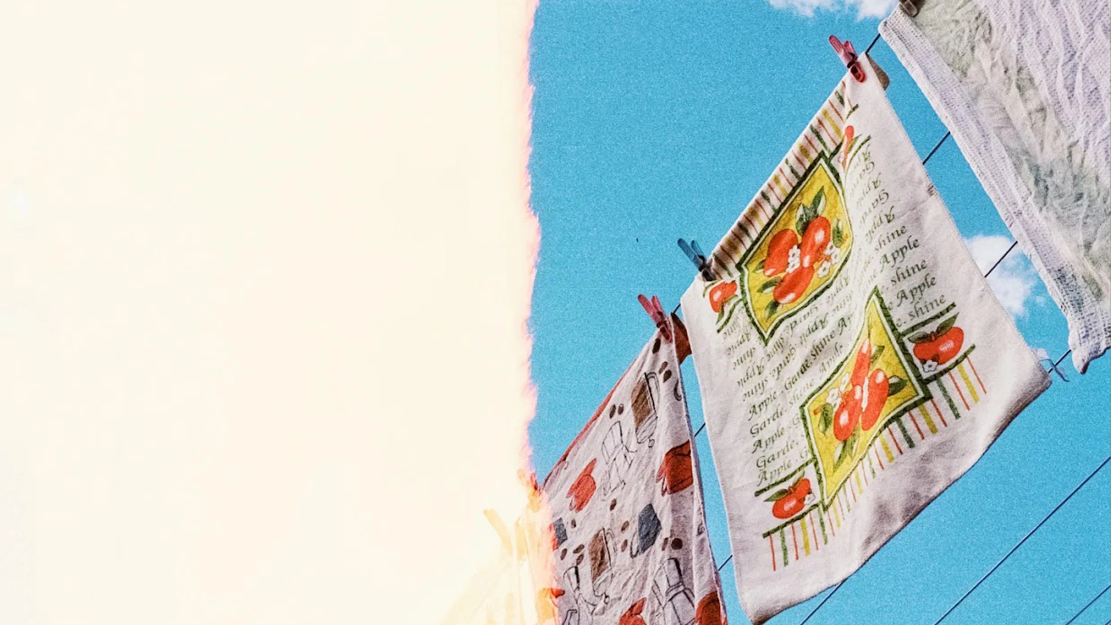 A Bunch Of Not-Quite-Poems About Nothing In Particular 2 Colourful Tea Towels With Fruit Patterns Hang On A Clothesline Under Blue Sky; Light Leak Left.