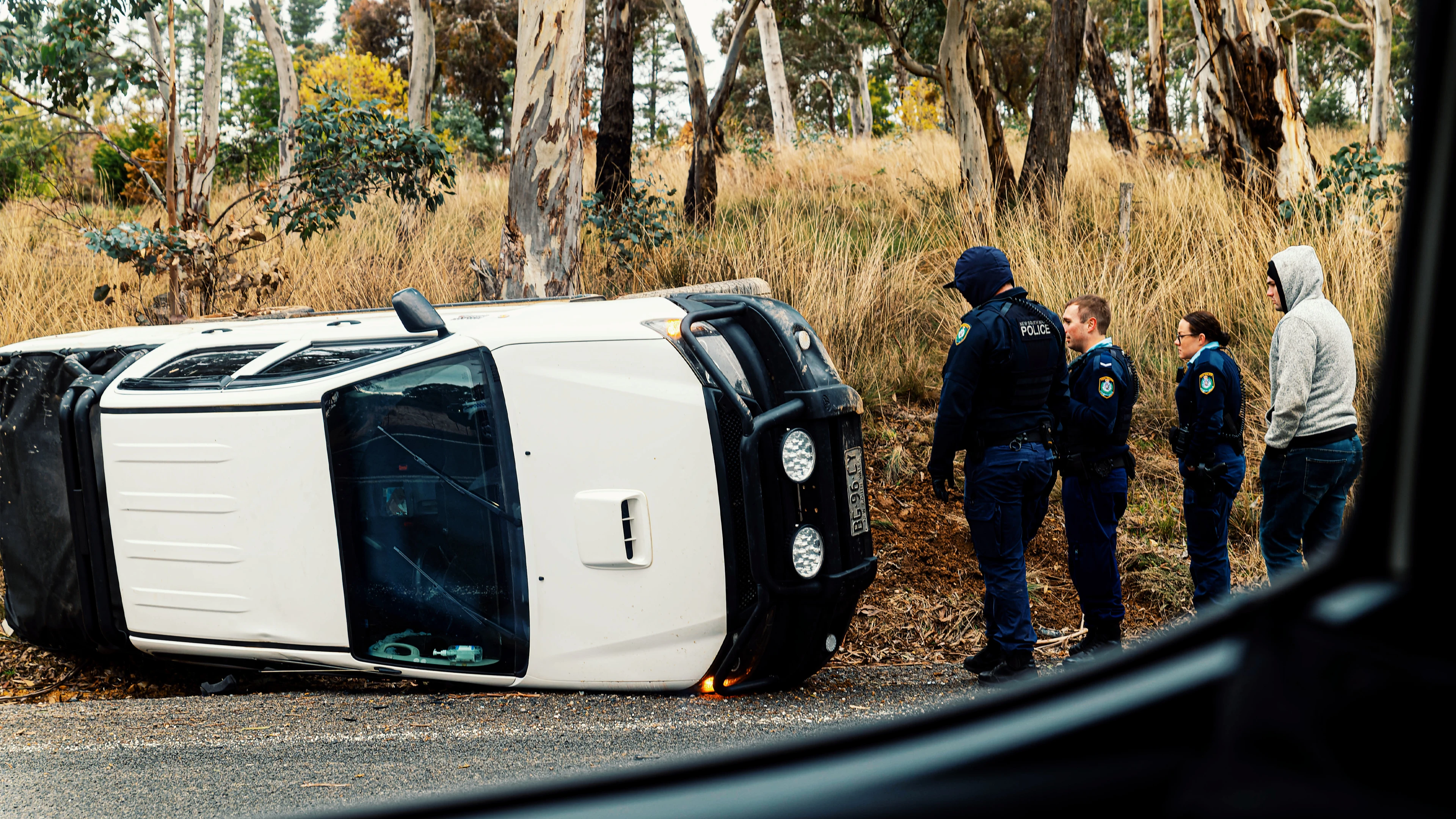 Perks Of Being A Tyneesha: Floods &Amp; Déjà Vu 1 Overturned White Vehicle By Road With Police And Onlookers Near Grassy Terrain And Trees.