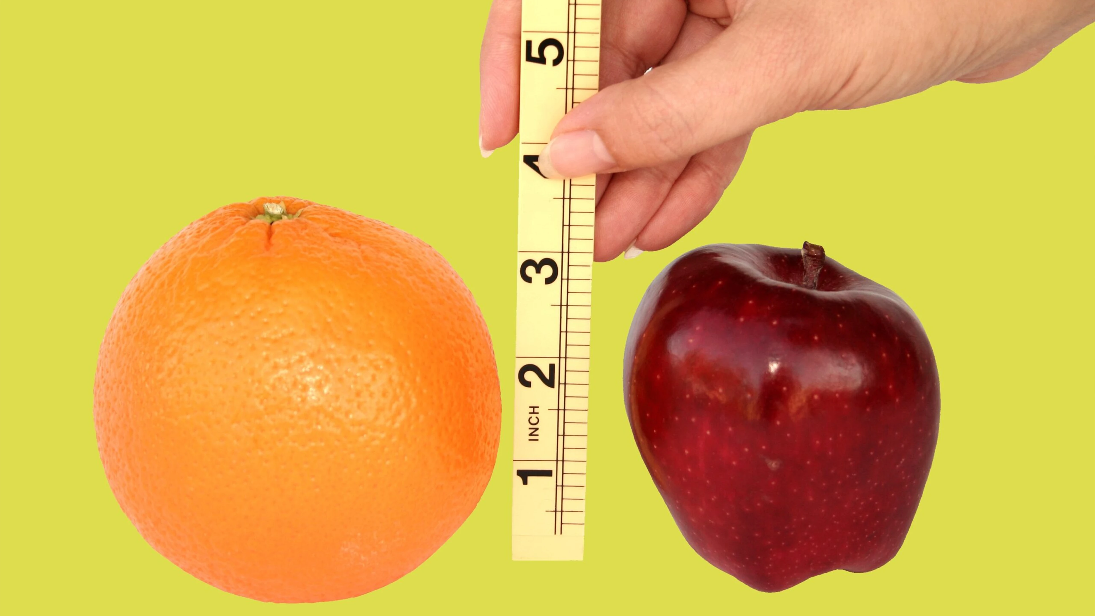 Stop Comparing And Start Creating! 5 Orange And Red Apple With A Hand Holding A Tape Measure On A Pale Green Background.