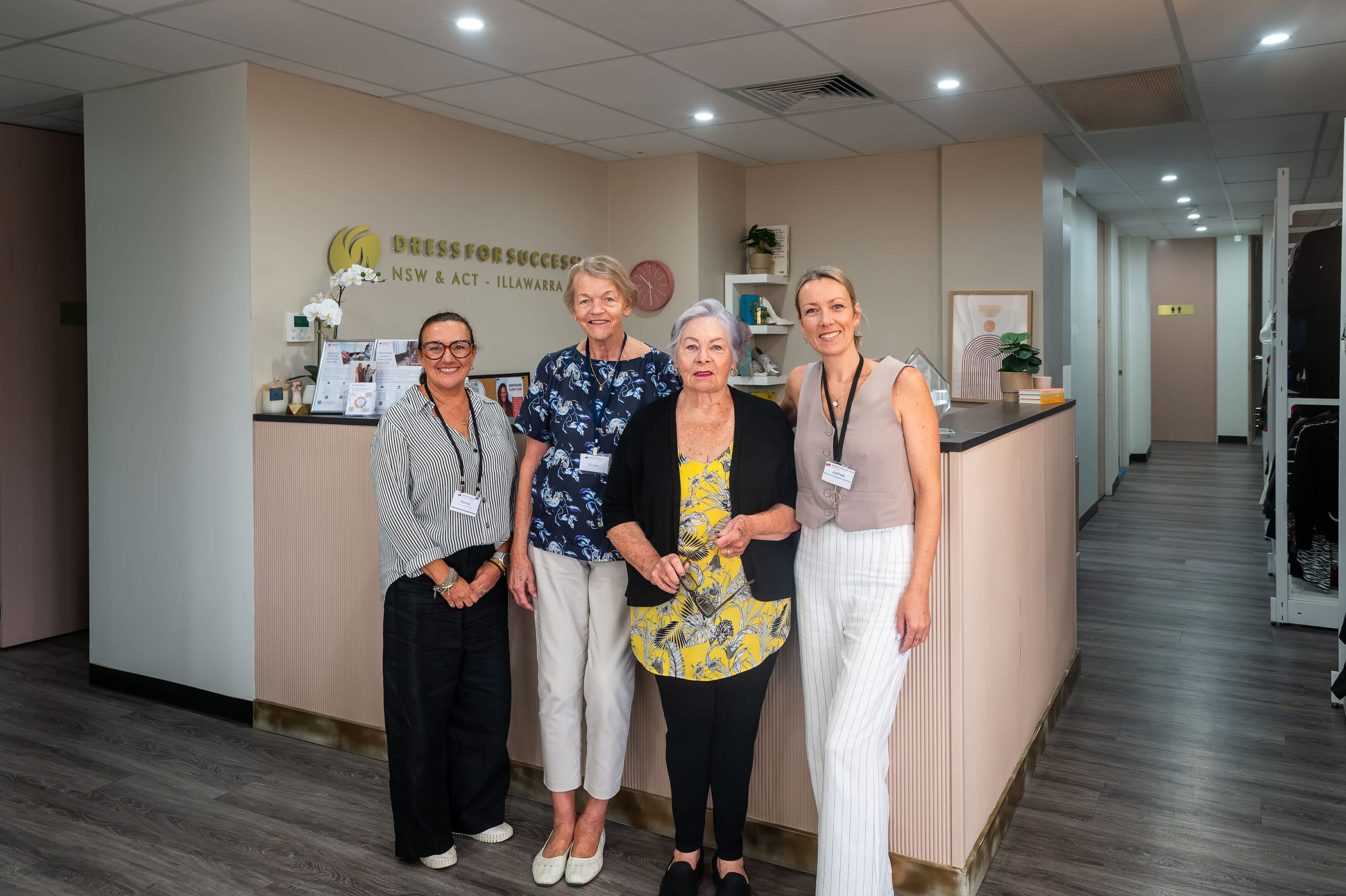 'Best Foot Forward': How Dress For Success Helps Empower Illawarra Women 18 Four Women In An Office With &Quot;Dress For Success Nsw &Amp; Act Illawarra&Quot; Sign In Background.